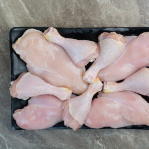 Fresh unprepared chicken legs on dark plate. High quality photo